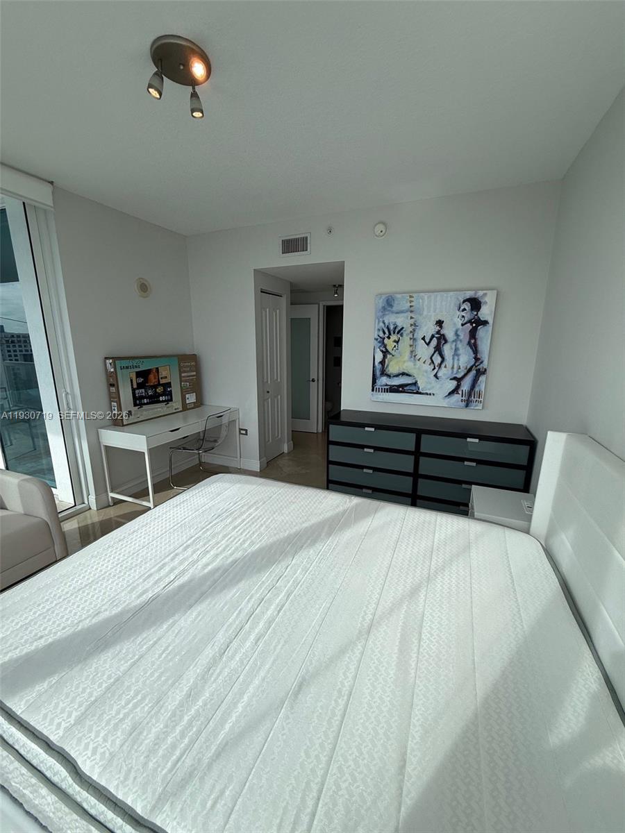 480 Northeast 30th Street, Unit 1505 Miami, FL 33137 - Photo 9 of 21 a bedroom with a bed and a flat screen tv