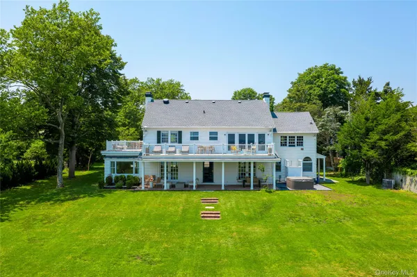 a view of a house with a big yard and large trees