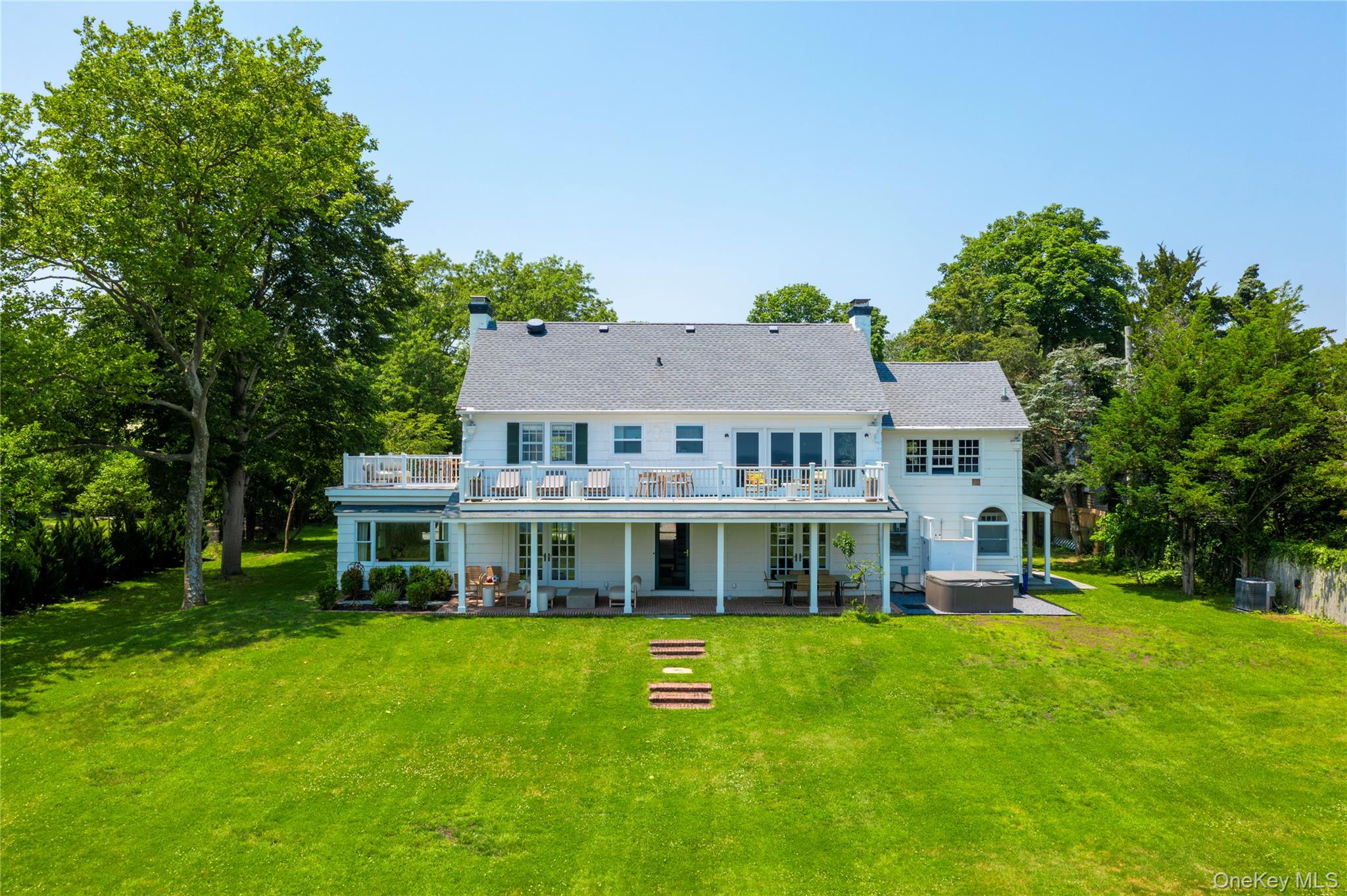 a view of a house with a big yard and large trees