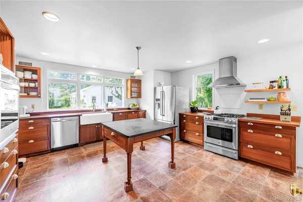 a kitchen with stainless steel appliances granite countertop a refrigerator and a sink