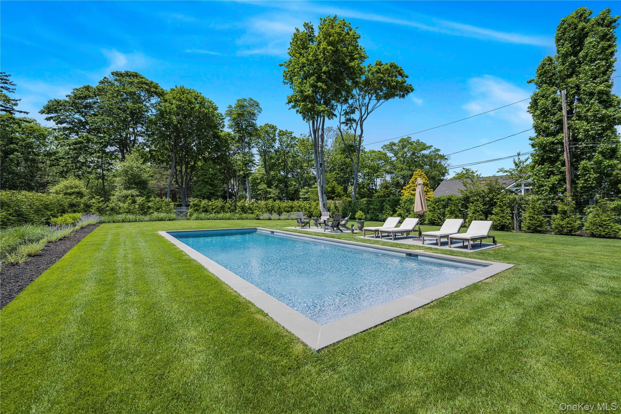 5 Thorn Hedge Road Bellport, NY 11713 - Photo 5 of 42 a view of a swimming pool with a yard