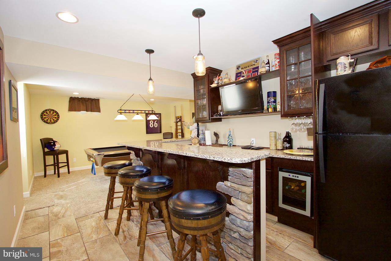 425 Spry Island Road Joppa, MD 21085 - Photo 19 of 30 Basement bar with granite countertop and fridge