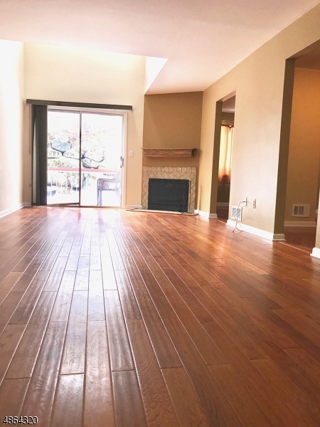 125 Patriots Road Morris Plains, NJ 07950 - Photo 3 of 12 a view of empty room with wooden floor and fireplace