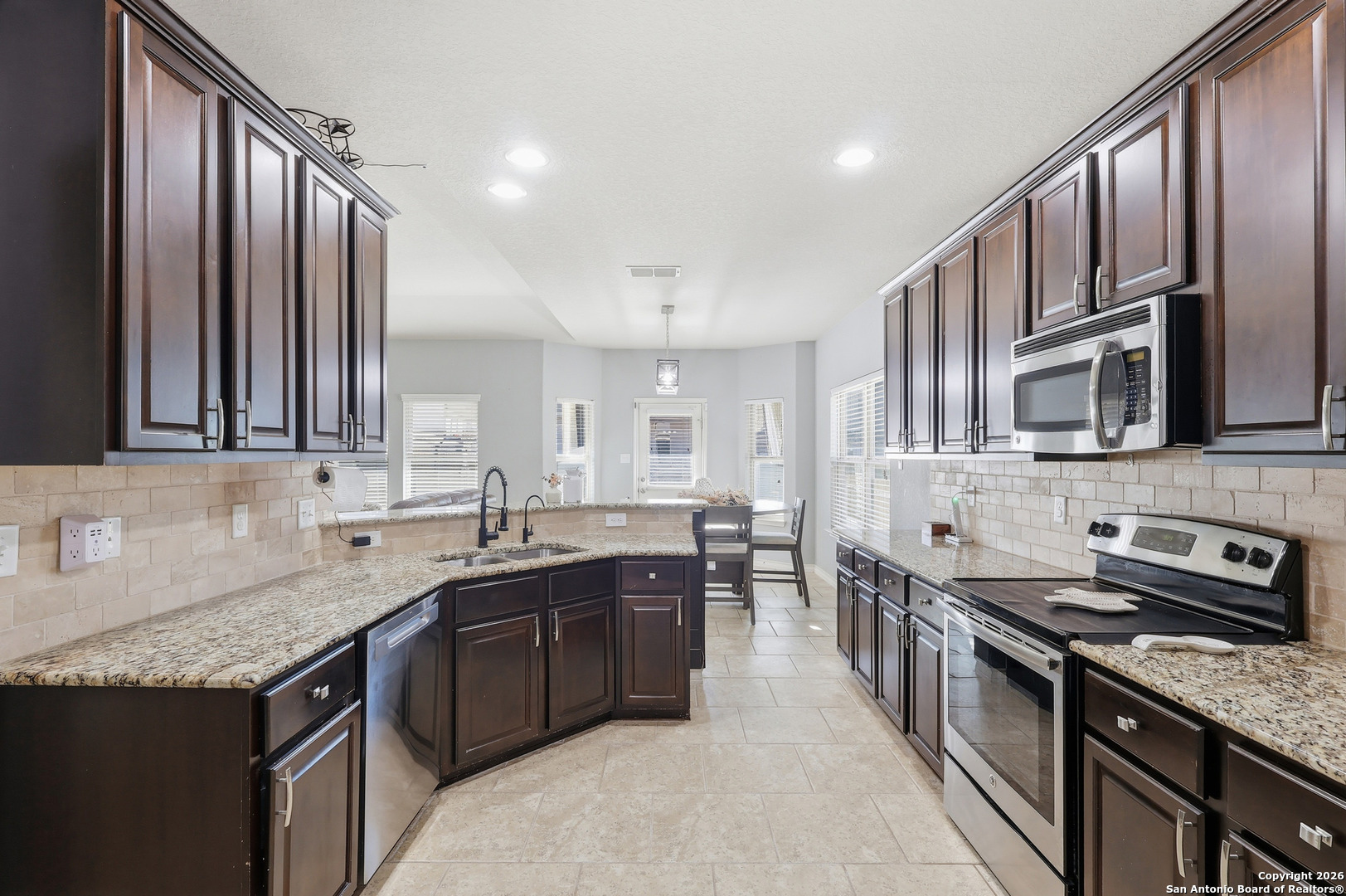 345 Morgan Run Cibolo, TX 78108 - Photo 4 of 22 a kitchen with stainless steel appliances granite countertop a sink stove and cabinets