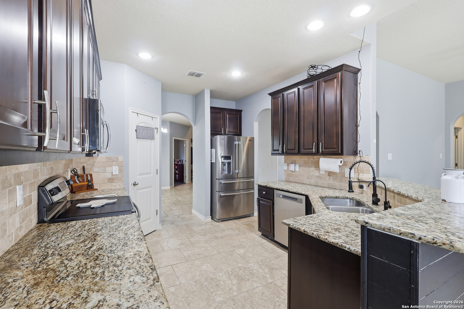 345 Morgan Run Cibolo, TX 78108 - Photo 7 of 22 a kitchen with stainless steel appliances granite countertop a sink stove and refrigerator