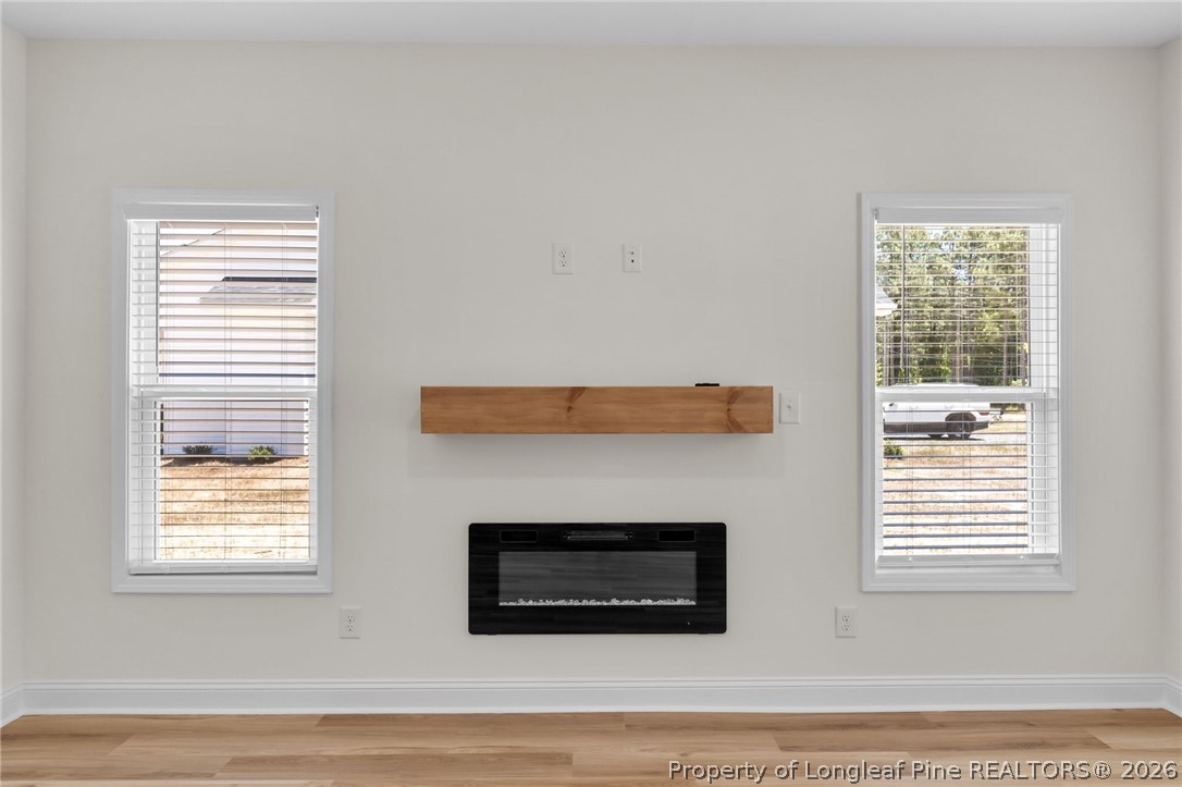 131 Merle Road Pinebluff, NC 28373 - Photo 8 of 33 a living room with a fireplace and windows