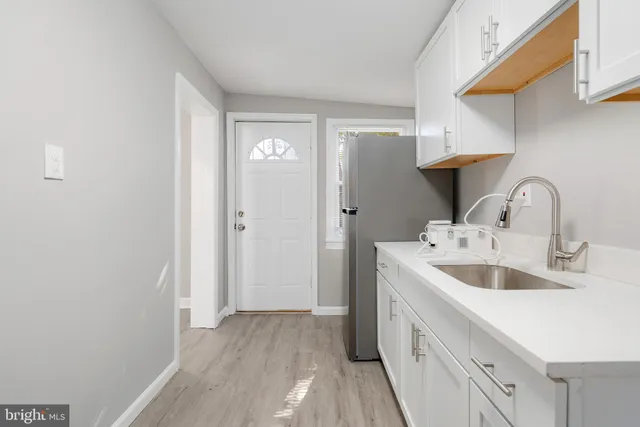 a view of a kitchen with a sink and wooden floor
