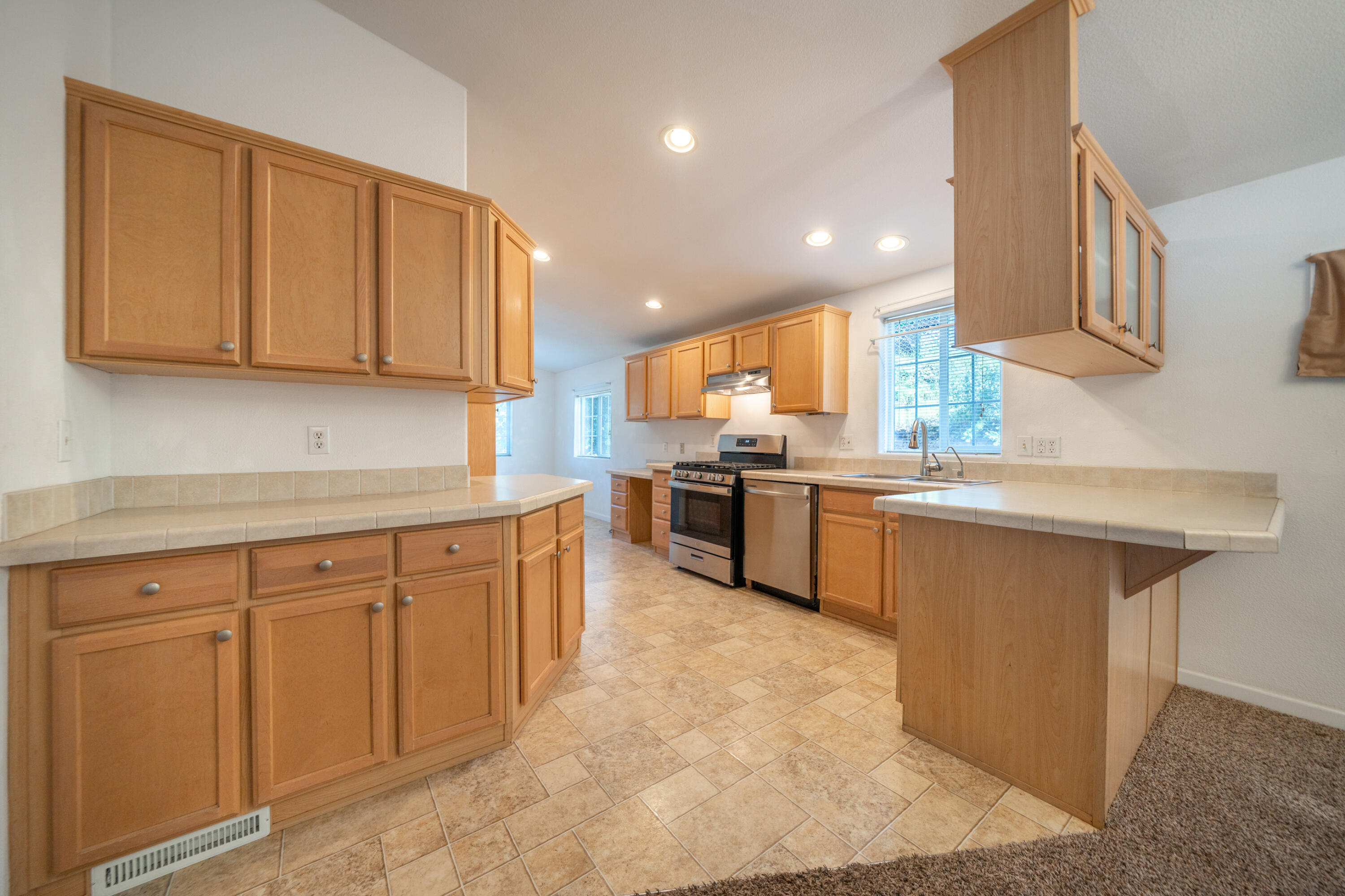 22151 Ravine Court Redding, CA 96003 - Photo 8 of 34 a kitchen with stainless steel appliances granite countertop a sink counter space cabinets and a large window