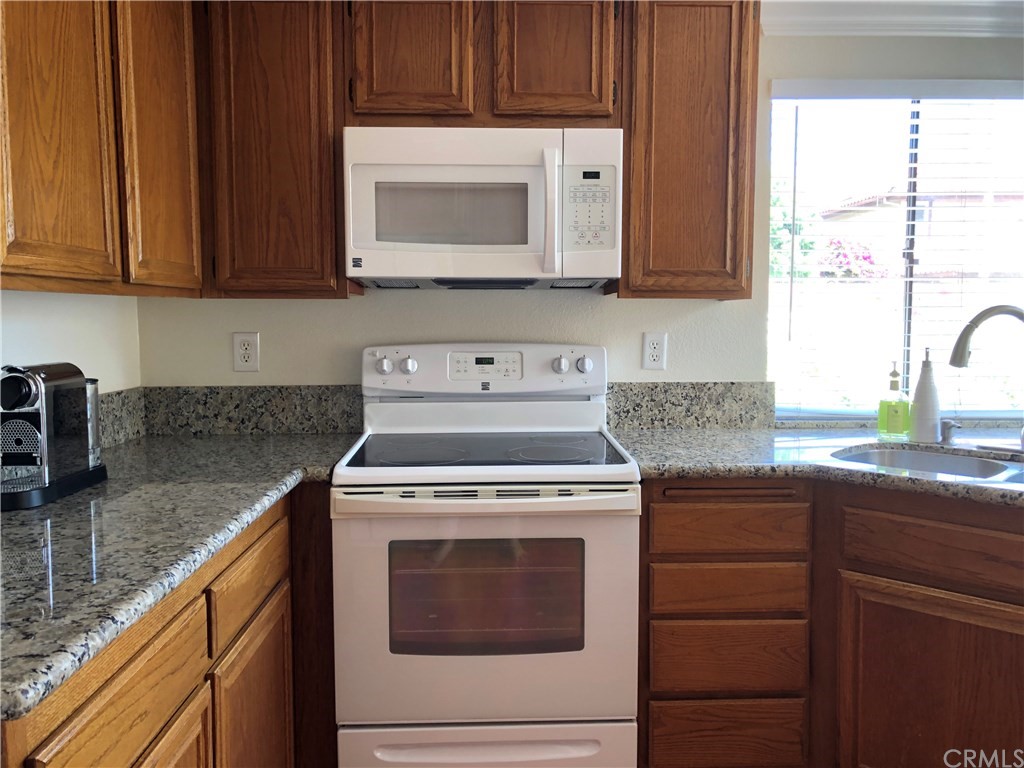 17 Filare Irvine, CA 92620 - Photo 23 of 46 a kitchen with stainless steel appliances granite countertop wooden cabinets stove top oven and sink