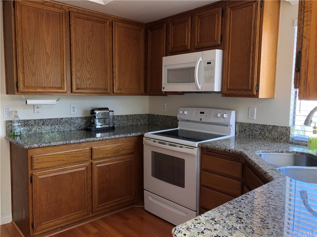 17 Filare Irvine, CA 92620 - Photo 25 of 46 a kitchen with stainless steel appliances granite countertop wooden cabinets a stove a sink and a microwave