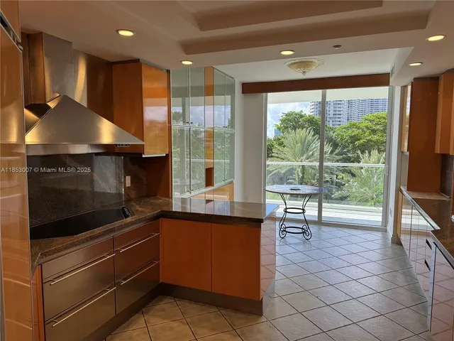 a kitchen with stainless steel appliances kitchen island granite countertop a sink and cabinets