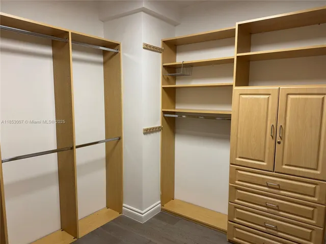a view of walk in closet with empty racks