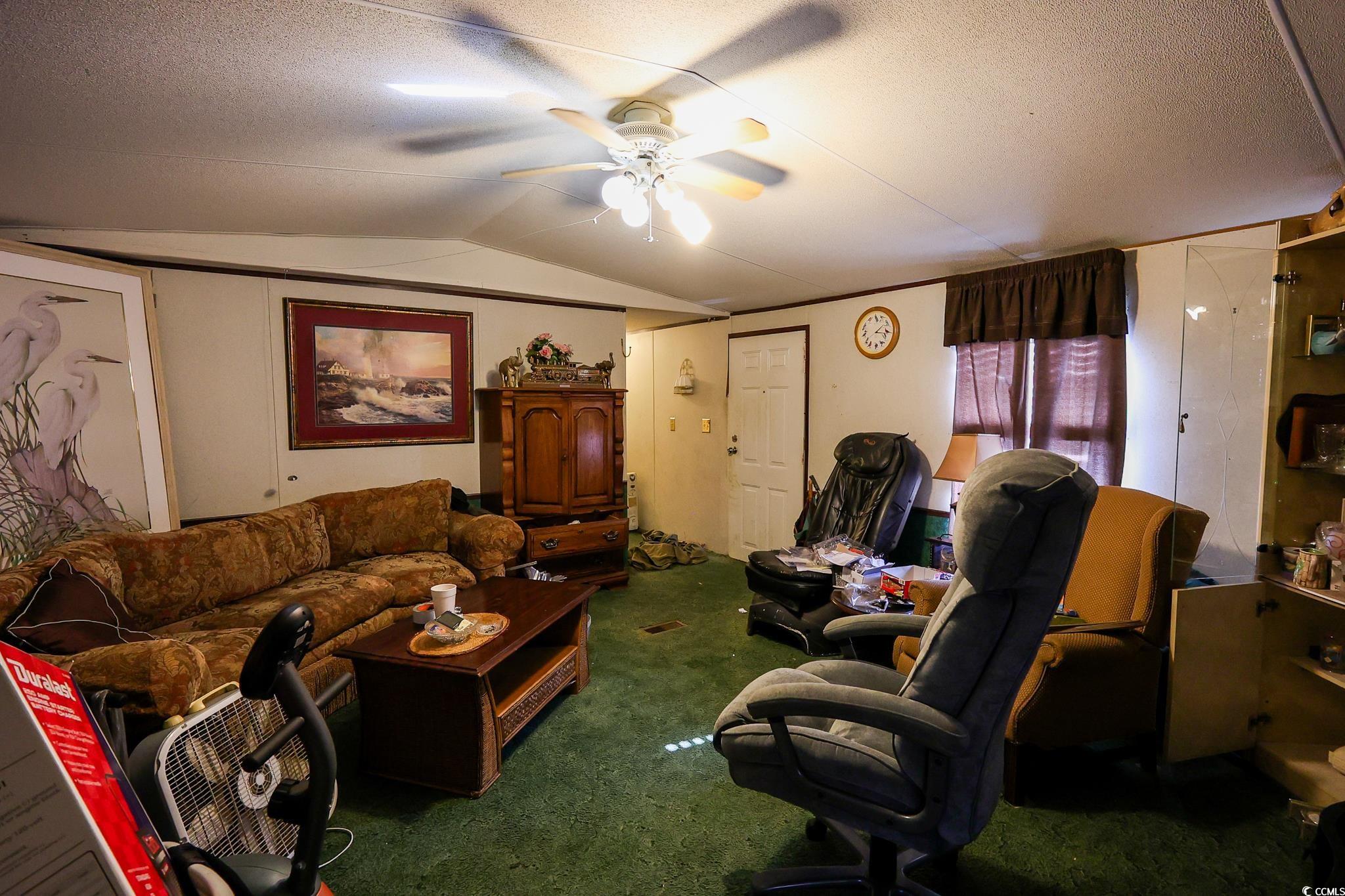 5266 Highmarket Street Georgetown, SC 29440 - Photo 3 of 17 Living room with lofted ceiling, ceiling fan, carpet floors, and a textured ceiling