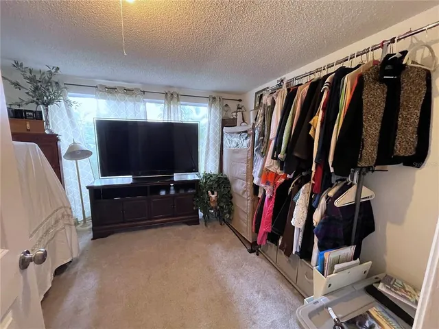 a living room with a flat screen tv and a walk in closet