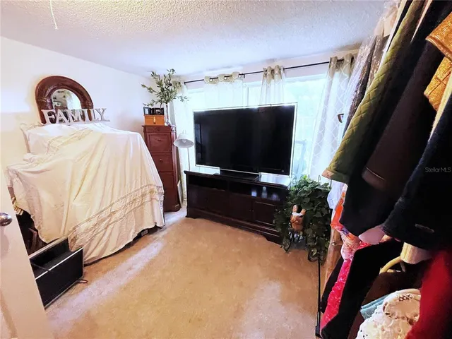 a bedroom with bed and flat screen tv