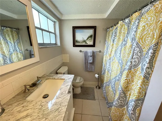 a bathroom with a granite countertop sink a mirror and a shower