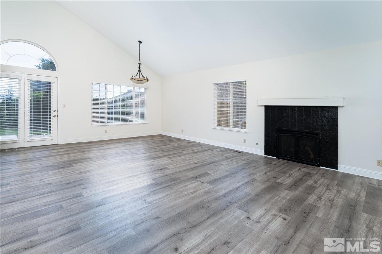 6284 Sunrise Meadows Loop Reno, NV 89519 - Photo 6 of 18 an empty room with wooden floor fireplace and windows