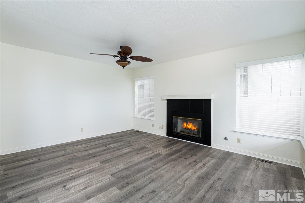 6284 Sunrise Meadows Loop Reno, NV 89519 - Photo 10 of 18 a view of an empty room with wooden floor fireplace and a window