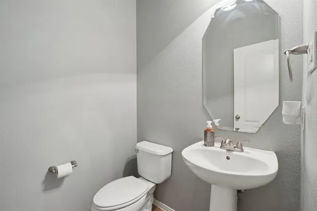 a bathroom with a sink a toilet and mirror