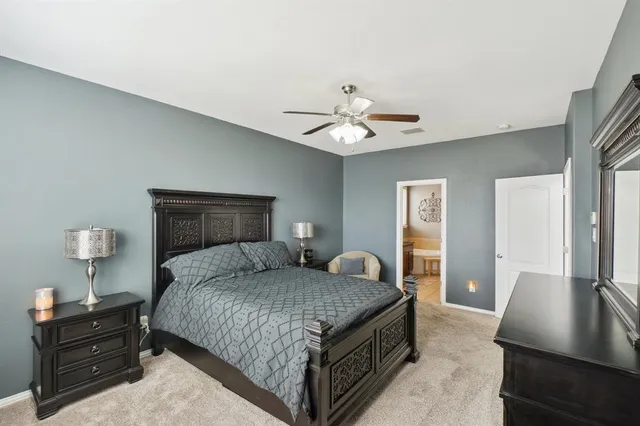 a bedroom with a bed and dresser with mirror