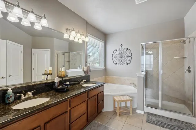 a bathroom with a double vanity sink toilet and shower