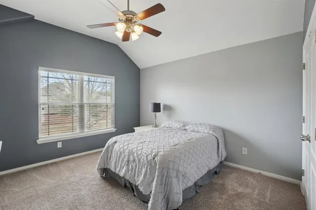 a bedroom with a bed and a ceiling fan