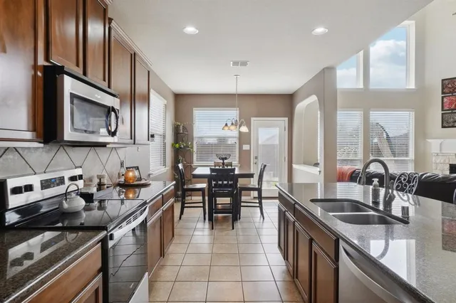 a kitchen with granite countertop cabinets and chairs