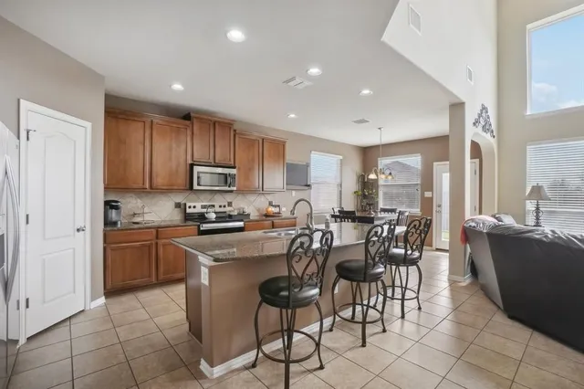a kitchen with stainless steel appliances granite countertop a sink and a refrigerator