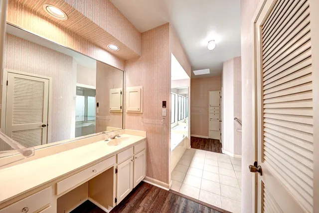 a spacious bathroom with a double vanity sink a mirror and a shower
