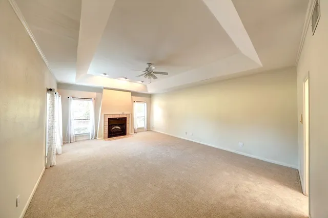 an empty room with windows and fireplace