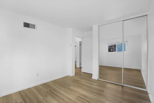 an empty room with wooden floor and door