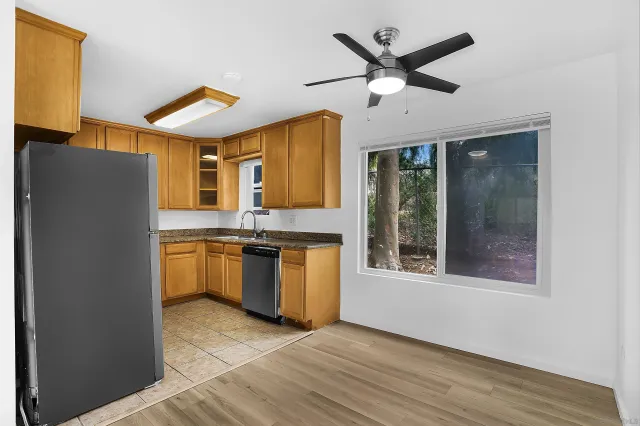 a kitchen with stainless steel appliances granite countertop a refrigerator a sink and a stove