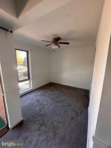 an empty room with a window and a ceiling fan