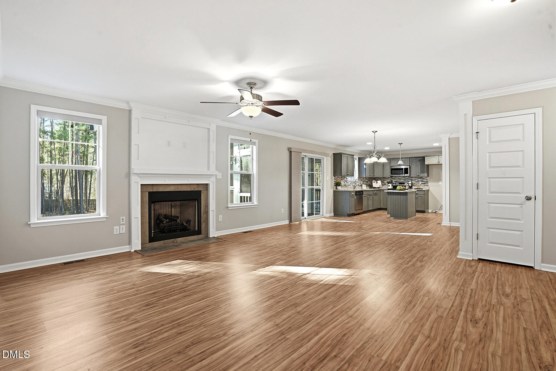 240 North Ridge Drive Louisburg, NC 27549 - Photo 6 of 31 a view of a livingroom with a fireplace a ceiling fan and wooden floor