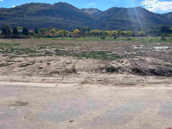 a view of dirt field with mountain view