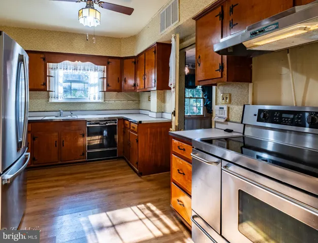 a kitchen with stainless steel appliances granite countertop a sink stove and cabinets