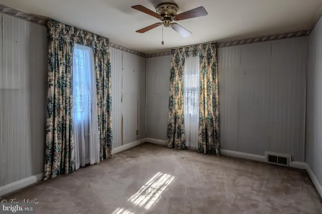 an empty room with windows and closet