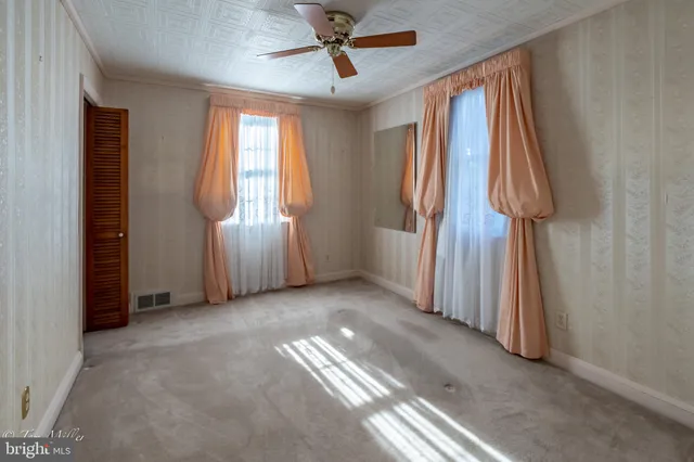 an empty room with windows and closet