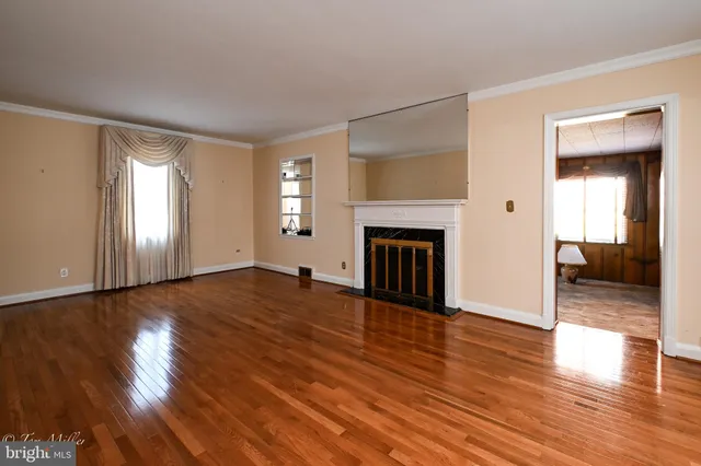 a view of a livingroom with wooden floor and a fireplace