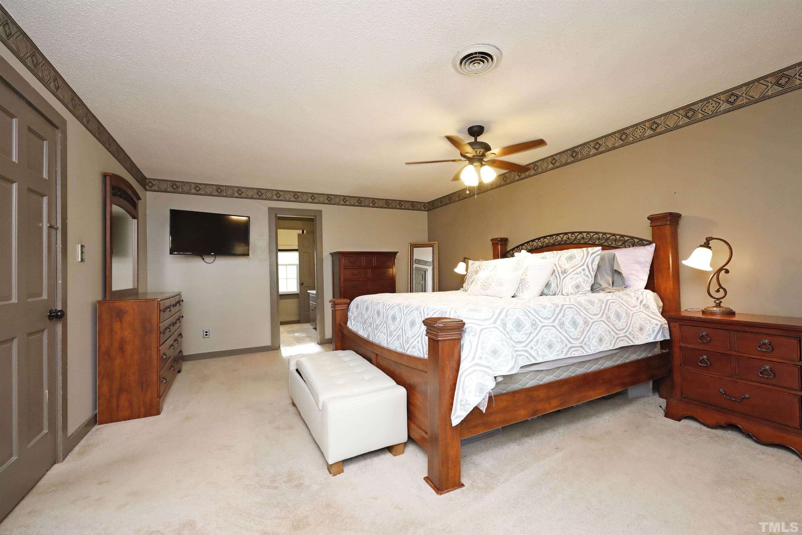 5308 Country Trail Raleigh, NC 27613 - Photo 29 of 51 a bedroom with a large bed and a chandelier