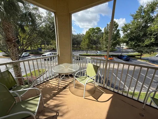 a view of a balcony with chairs and wooden fence