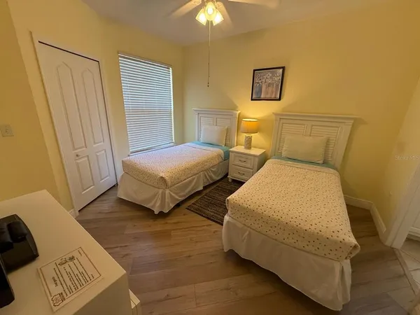 a bedroom with two beds and a chandelier