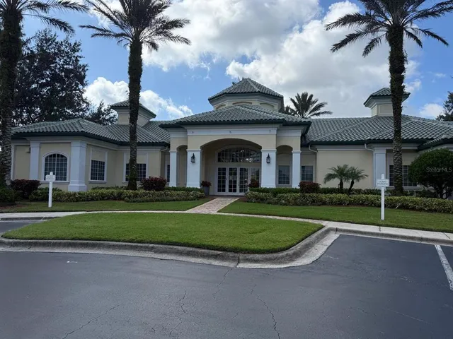 a view of a house with a big yard plants and palm trees