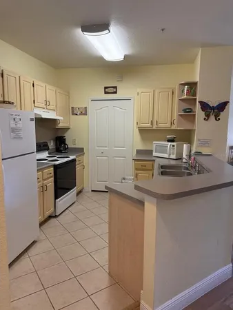 a kitchen with kitchen island granite countertop a sink cabinets and stainless steel appliances