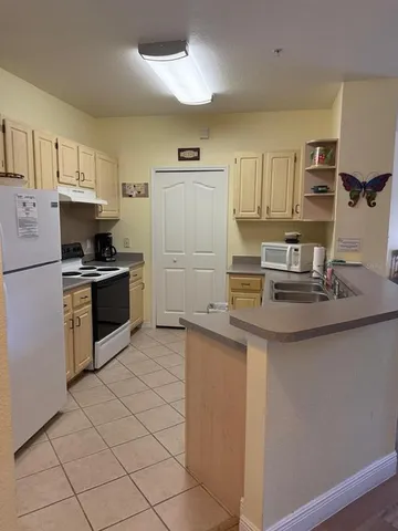 a kitchen with kitchen island granite countertop a sink cabinets and stainless steel appliances