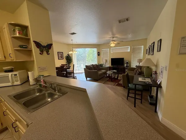 a living room with furniture a flat screen tv and a sink