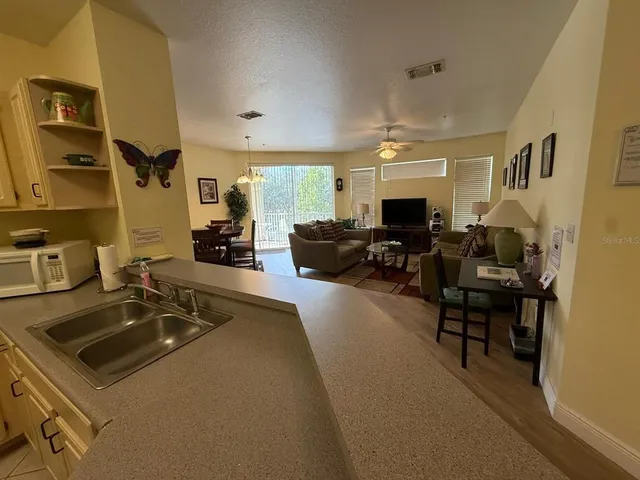 a living room with furniture a flat screen tv and a sink