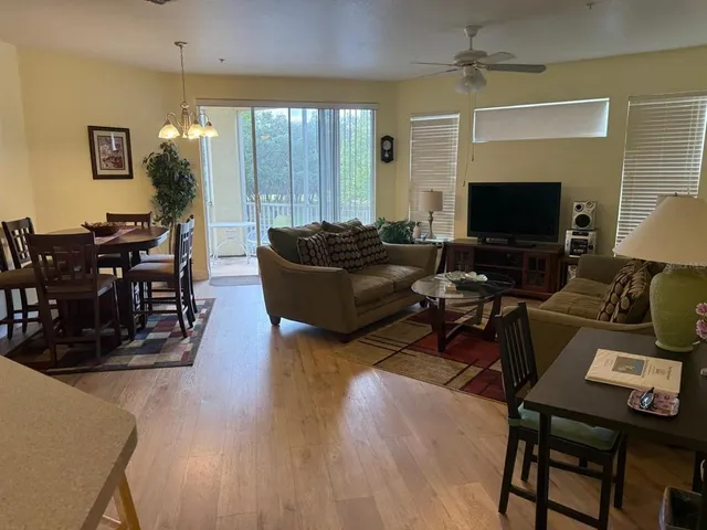 a living room with furniture a dining table and a flat screen tv