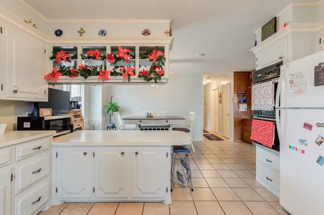 a kitchen with white cabinets and sink