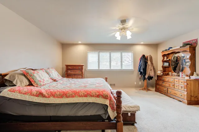 a bedroom with a large bed and a chandelier
